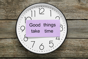 Phrase Good Things Take Time and clock on wooden table, top view. Motivational quote