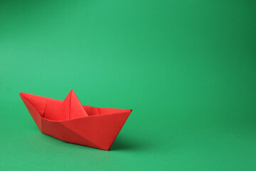Fototapeta premium Origami art. Paper boat on green background, space for text