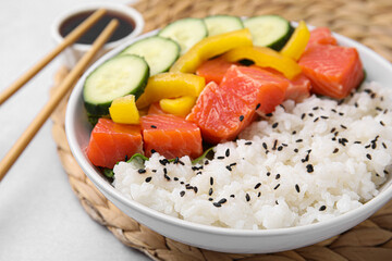 Delicious poke bowl with salmon, rice and vegetables on white table, closeup