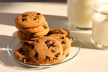 Delicious chocolate chip cookies and milk on white marble table