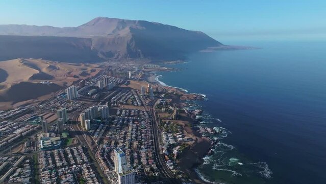 Slow motion aerial shot overhead Iquique, Chile with large skyscrapers