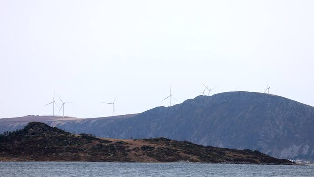 Hest&oslash;ya with Harams&oslash;ya and the wind turbines on Haramsfjellet in the background. Harams&oslash;ya is just north of &Aring;lesund City, and has almost 600 people living there.