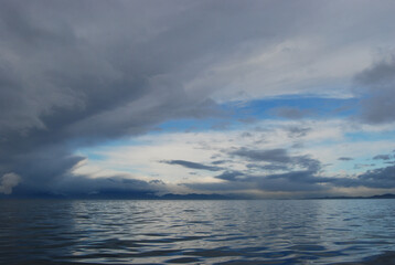 Fototapeta na wymiar Reflections of storm clouds on a wavy but calm Juan De Fuca Strait near Victoria, BC