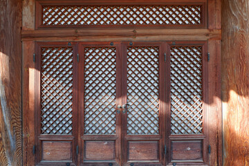 Wooden door  and wall of asian traditional architecture. Dark and  brown window  with oriental...