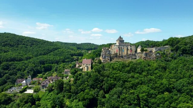 4K aerial footage of the Chateau de Castelnaud-la-Chapelle, which is a medieval fortress in the commune of Castelnaud-la-Chapelle, overlooking the river Dordogne in P&eacute;rigord, Southern France.