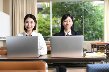ノートパソコンで勉強する女子学生達