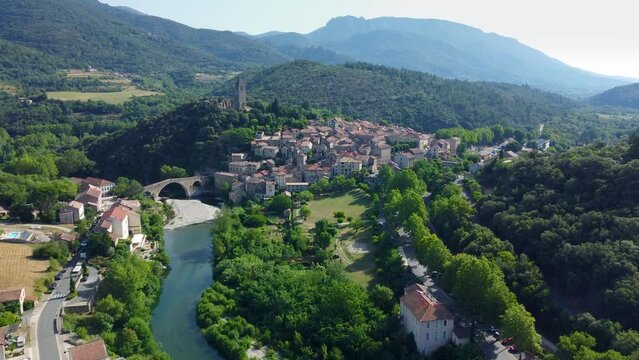Smooth 4K aerial footage of the medieval town of Olargues featuring the Devil's Bridge in the H&eacute;rault department in the Occitanie region in southern France