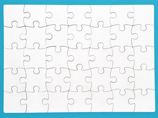 White jigsaw puzzle on blue background, top angle view