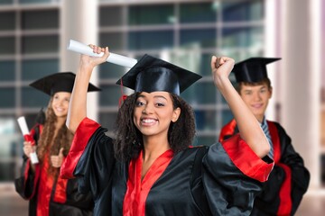 happy young students in graduation costumes