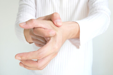 Man massaging thumb and finger pain, trigger finger from work and office syndrome On a white...