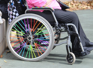 A disabled woman in a wheel chair. The wheelchair is decorated in rainbow colours. WorldPride,...