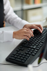 Hands of social consultant typing on keyboard