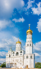 Ivan the Great Bell Tower, with Assumption Belfry on the right in Moscow Kremlin. Blue sky background with sunbeams