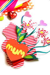 Child creating homemade greeting card. Paper vase with bouquets of flowers and hearts, gift for Mothers day, Birthday or Valentines day . Arts  crafts concept. Preshool crafts