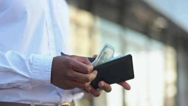 Hands, city and money wallet with dollars for payment, banking or investment outdoors. Finance, business cash and black man with currency, bills or wealth for financial purchase, spending or income.