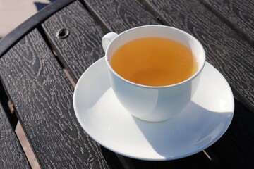 A Cup of green tea on black wooden background. Cleansing or detox tea is a good option for weight loss. Antioxidant properties. Copy space