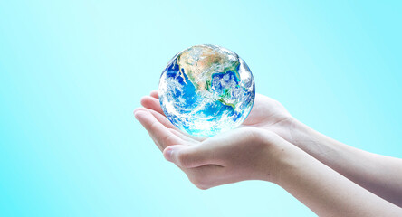 Hand holding blue planet earth globe with blurred background . Elements of this image furnished by NASA.