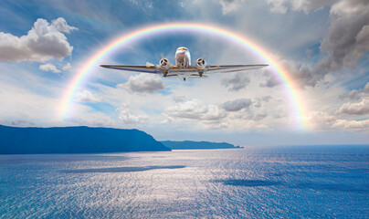 Vintage type old metallic propeller airplane in the sky, sunset clouds with calm sea in the background