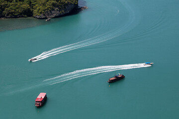 A bird's-eye view of various tour boats sailing in the sea, the white waves look beautiful.