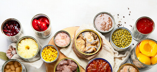 Canned vegetables, beans, fish and fruits in tin cans on a white background. Food stocks.