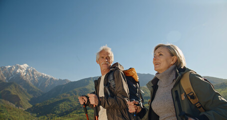 Mature caucasian couple on vacation, having a hike in spring mountains, spending time together...