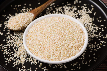 white sesame seeds in plate on wooden table