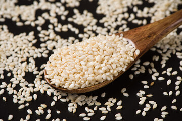 white sesame seeds in spoon on table.