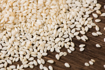 closeup of white sesame seeds on wooden table