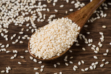 white sesame seeds in spoon on table.