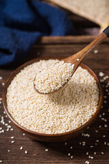white sesame seeds in wooden bowl on table.