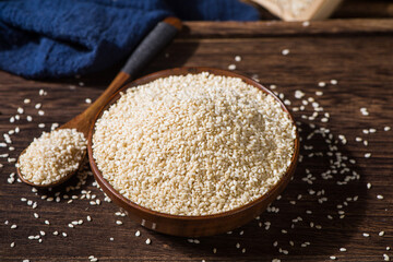white sesame seeds in wooden bowl on table.