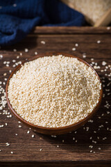 white sesame seeds in wooden bowl on table.