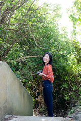 Naklejka na ściany i meble 沖縄の森で写真を撮るカメラ女子