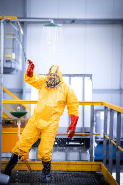 Worker in chemicals production plant taking a shower to wash away the acid after the accident. Occupational health and safety.