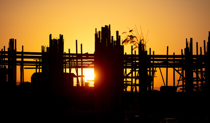 Silhouette building construction at sunset.