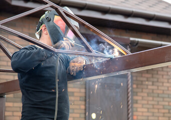 The worker installs the metal on the canopy.
