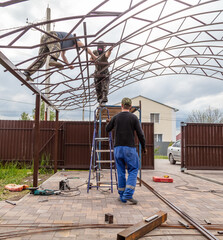 The worker installs the metal on the canopy.