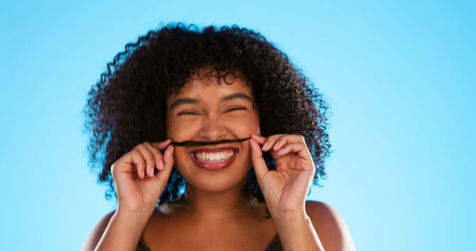 Hair, moustache and a playful black woman joking in studio on a blue background for fun or games. Portrait, face or haircare and a silly young female comic playing with her hairstyle in comedy