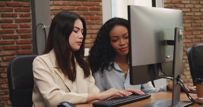 Two beautiful business women working on a new project together while working in the office.