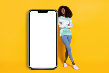 Full body portrait of cheerful charming lady crossed hands look empty space telephone ui menu isolated on yellow color background