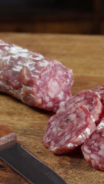 saucisson sec tranch&eacute; en gros plan sur une table en bois	