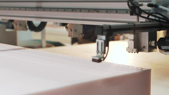 close-up shot of a factory machine automatically applying glue to the material for making a mattress in a textile production