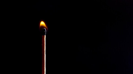 burning match on solid black background