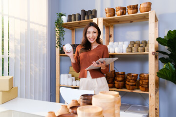 Asian beautiful woman sell handmade vase products online live streaming at home. Young attractive girl check stock and supply of goods before selling. Remote buying and purchase shopping concept.