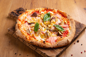 Capricciosa pizza with cheese, bacon, tomatoes, mushrooms and basil, italian meal.