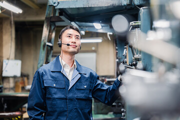 ヘッドセットをつけて重機を操作する男性作業員