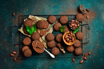 Chocolate candies, truffles, chocolates and cocoa beans. Sweets, pastries, brownies On a dark background. Top view.