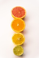Simple composition of citrus fruits places in a line on the white desk. 
