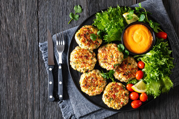 crab cakes with sauce, lettuce, tomatoes, lemon