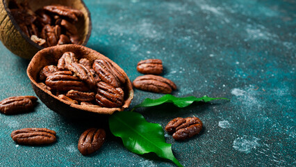 Pecan. Caramelized walnut in a bowl. Side view. On a dark background.